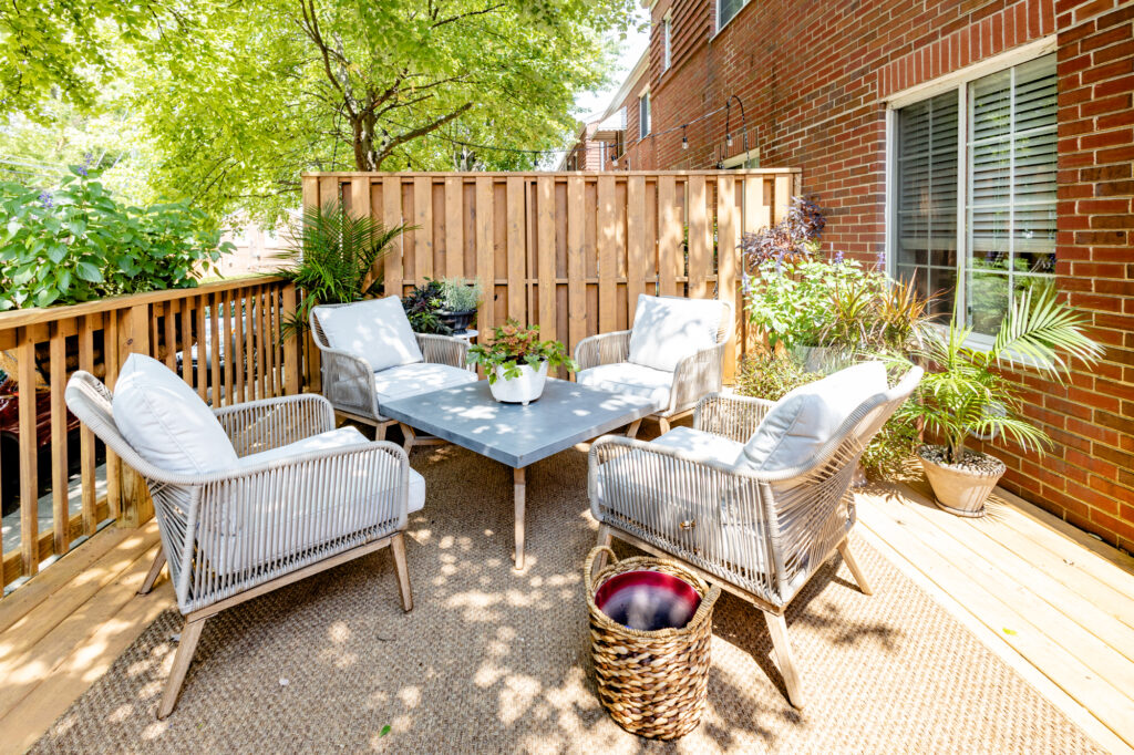 patio with wicker furniture setting while dappled sunlight shines down