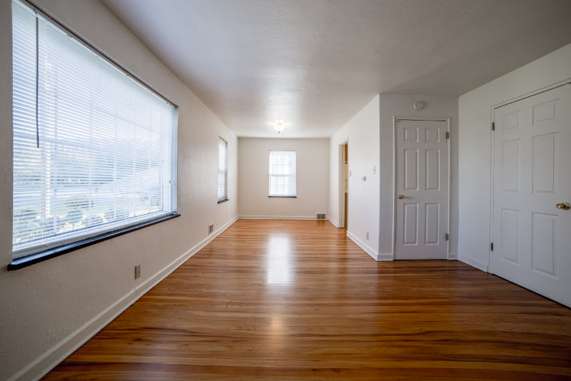 empty living room with wooden floors and white walls